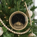 A Christmas tree decorated with ornaments, including a circular ornament with a starry night sky design and the text "The Little Dipper" below it.