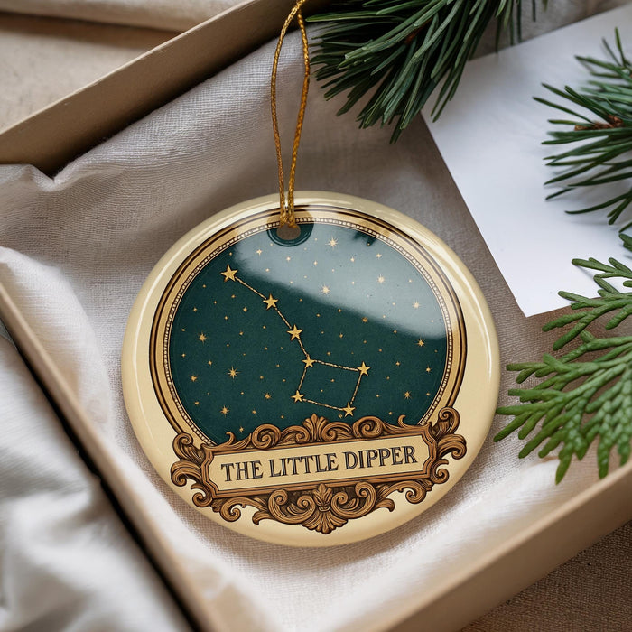 A decorative ornament with a starry night sky design and the text "THE LITTLE DIpper" on it, hanging from a string.