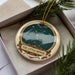 A decorative ornament in a box, featuring a starry night sky design and the text "THE LITTLE DIpper".