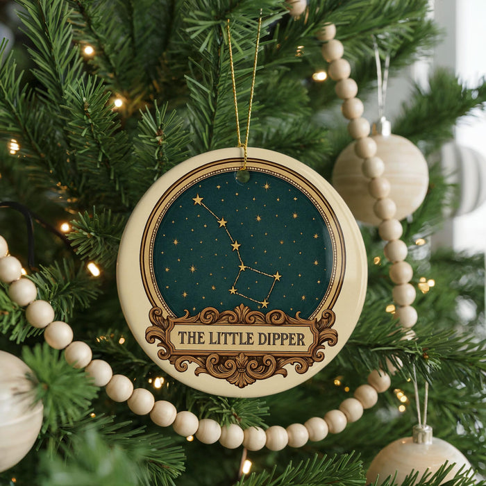 A Christmas tree decorated with ornaments, including a circular ornament with a starry night sky design and the text "The Little Dipper".