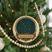 A Christmas tree decorated with ornaments, including a circular ornament with a starry night sky design and the text "The Little Dipper".