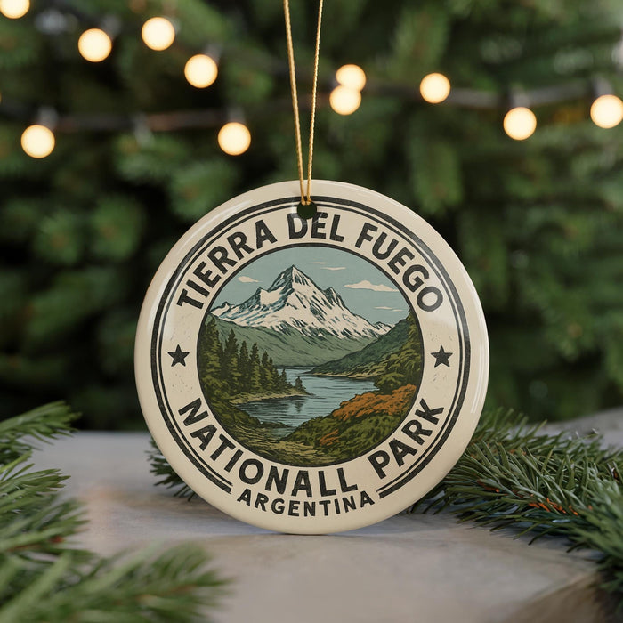 A circular ornament with the text "TIERRA DEL FUEGO NATIONALL PARK ARGENTINA" and a mountain landscape design, hanging from a string.
