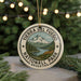A circular ornament with the text "TIERRA DEL FUEGO NATIONALL PARK ARGENTINA" and a mountain landscape design, hanging from a string.