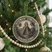 A circular ornament on a Christmas tree, featuring an illustration of the Mayan pyramid of Chichen Itza in Guatemala.