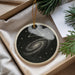A decorative ornament in a box, featuring a starry night sky design with a spiral galaxy.