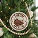 A Christmas tree decorated with ornaments, including a circular ornament with the text "TULUM MEXICO" and a palm tree illustration.