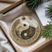 A decorative ornament with a yin and yang symbol, featuring a temple and mountains, is displayed in a box with pine branches.