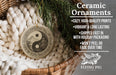 Ceramic ornaments, a ceramic ornament with a yin and yang symbol, are displayed in a woven basket.