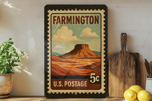 A framed vintage postage stamp depicting a mountain landscape hangs on a wall, surrounded by kitchen utensils and a potted plant.