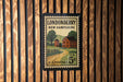 A vintage postage stamp from New Hampshire, featuring a rural scene with a house, road, and trees.