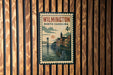 A postage stamp from North Carolina, featuring a cityscape with a bridge and river, is displayed on a wooden wall.