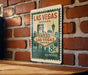 A vintage-style metal sign that reads "Welcome to Fabulous Las Vegas Nevada" and features the iconic Las Vegas skyline.