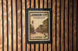 A U.S. postage stamp from Johnson City, Tennessee, mounted on a wooden wall.