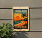 A vintage-style sign for Virginia Beach, featuring a palm tree, sunset, and beach scene, mounted on a wall.