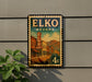 A vintage-style sign for the Elko Nevada Hotel, featuring a colorful illustration of a small town street with buildings and a car.