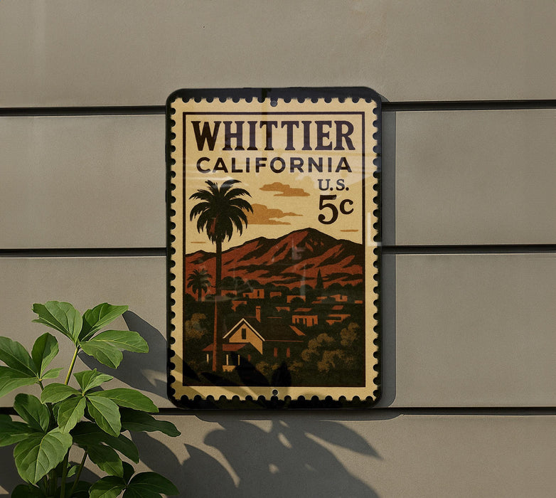 A vintage postage stamp from California, featuring a palm tree and a mountain landscape, is displayed on a wall.