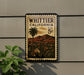 A vintage postage stamp from California, featuring a palm tree and a mountain landscape, is displayed on a wall.