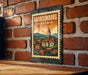 A vintage postage stamp depicting a town of Harrisonburg, Virginia, is displayed on a brick wall.
