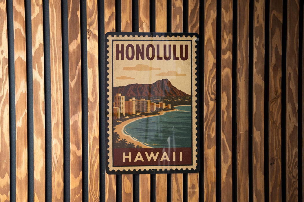 A vintage-style poster of Honolulu, Hawaii, with a mountain and ocean in the background, is displayed on a wooden wall.