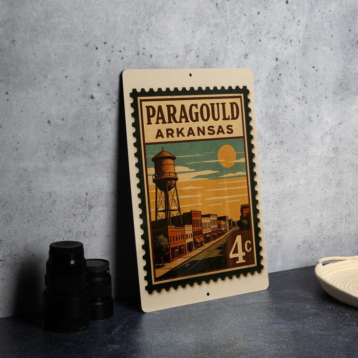 A vintage postage stamp from Arkansas featuring a water tower and a city street scene.