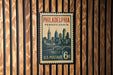 A vintage U.S. postage stamp from Philadelphia, Pennsylvania, featuring a cityscape and a bridge.