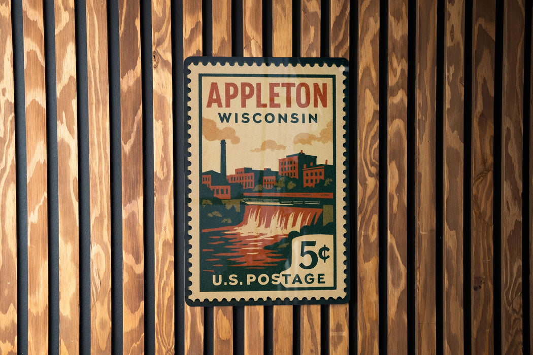 A vintage postage stamp from Wisconsin, featuring an illustration of a waterfall and buildings, mounted on a wooden wall.