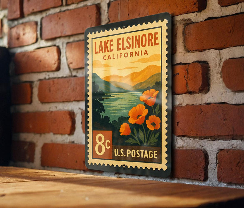 A vintage-style postage stamp depicting Lake Elsinore, California, with a scenic landscape and orange flowers.