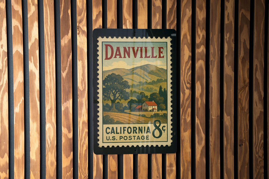 A vintage California U.S. postage stamp is displayed on a wooden wall.