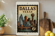 A vintage-style postage stamp depicting the skyline of Dallas, Texas, with the text "DALLAS TEXAS" prominently displayed.