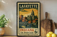 A vintage postage stamp from Lafayette, Indiana, depicting the cityscape and a bridge, is displayed on a shelf next to a wooden cutting board and some lemons.