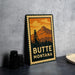 A vintage-style metal sign with a mountain and a tower in the background, along with the text "BUTTE MONTANA" prominently displayed.