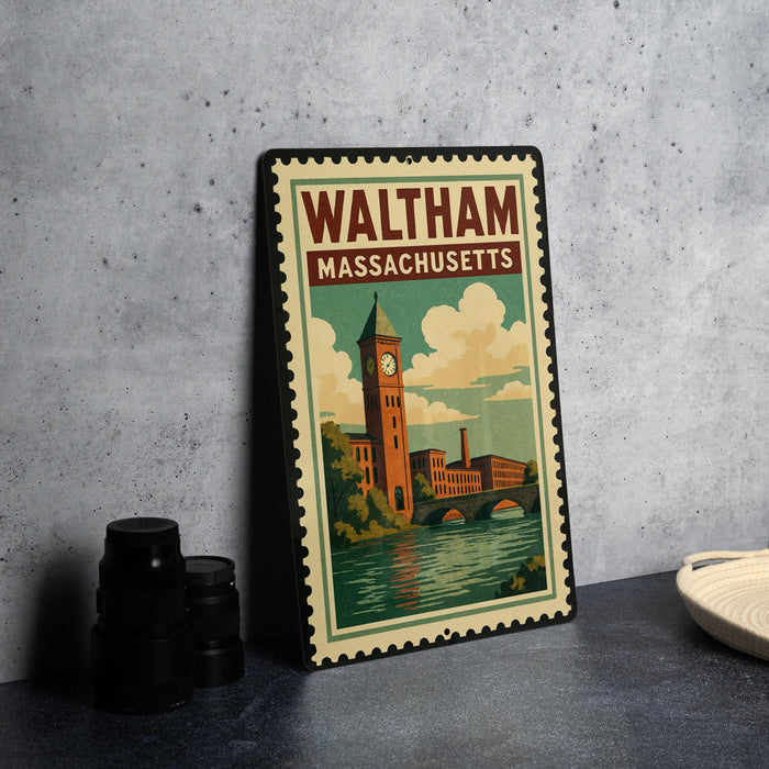 A vintage-style metal sign with the text "WALTHAM MASSACHUSETTS" and an illustration of a clock tower and a river, placed on a gray concrete surface.