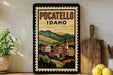 A framed vintage-style poster of POCATELLO, Idaho, featuring a colorful illustration of a town nestled among mountains.