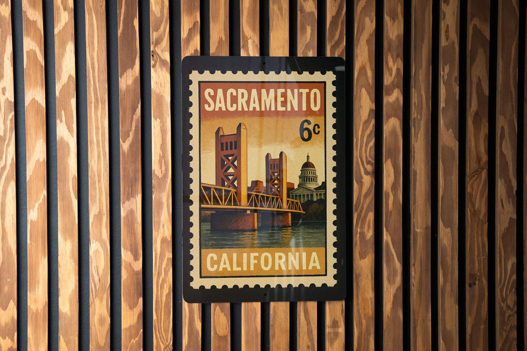 A framed California postage stamp featuring the Golden Gate Bridge, mounted on a wooden wall.