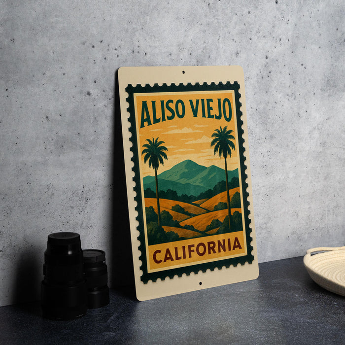 A framed poster of a scenic landscape with palm trees and mountains, featuring the text "ALISO VIEJO CALIFORNIA" on the poster.