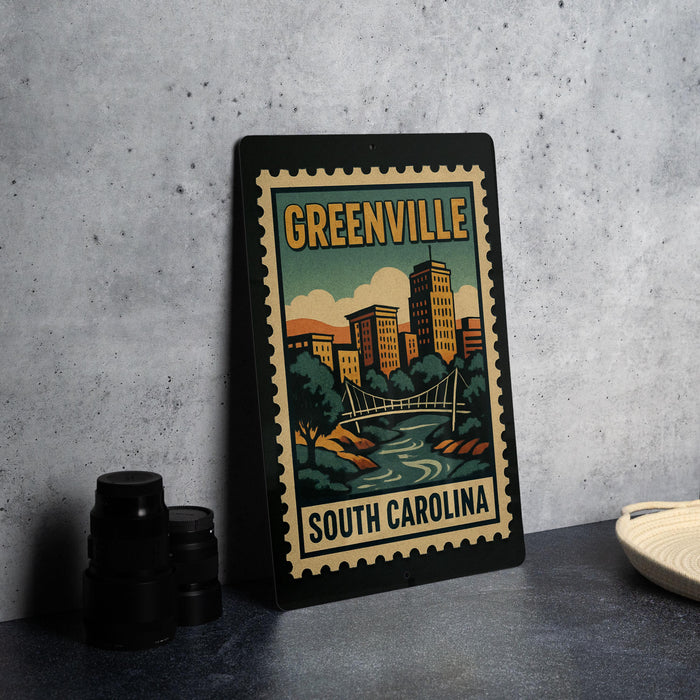 A framed poster of Greenville, South Carolina, featuring a cityscape and a bridge, is displayed on a countertop.