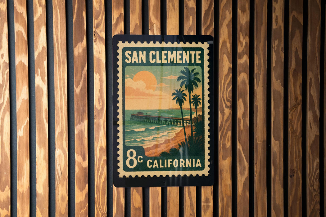 A vintage-style postage stamp from San Clemente, California, featuring a beach scene with palm trees and a pier.