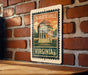 A vintage postage stamp featuring the University of Virginia, with a brick wall in the background.