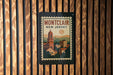 A framed poster of Montclair, New Jersey, is displayed on a wooden wall.