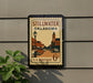A vintage postage stamp from Stillwater, Oklahoma, featuring a street scene with buildings and cars.