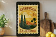 A framed vintage postage stamp depicting a scenic landscape of Brentwood, California, with palm trees and mountains in the background.