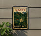 A vintage-style metal sign with the text "CAEY PUERTO RICO" displayed on it, featuring a tropical landscape with palm trees and a church.