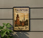 A vintage U.S. postage stamp from Massachusetts, featuring a clock tower and other architectural elements, mounted on a wall.