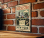 A vintage-style metal sign with the text "Rochester New York" and a cityscape illustration, mounted on a brick wall.