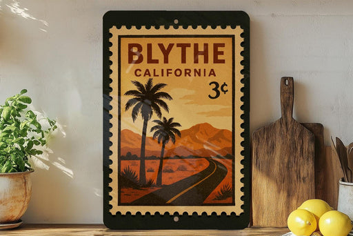 a framed poster of a tropical road scene with palm trees and mountains, placed on a shelf next to a wooden cutting board and some lemons.