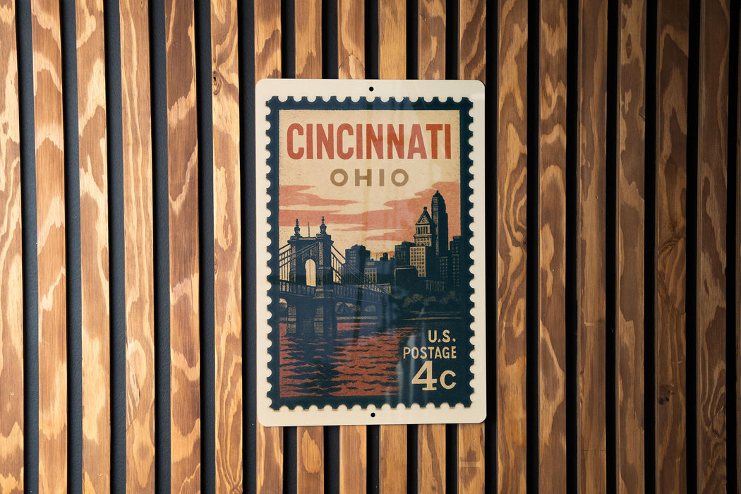 A vintage-style postage stamp from the United States, featuring the city of Cincinnati, Ohio, with a bridge and skyline in the background.