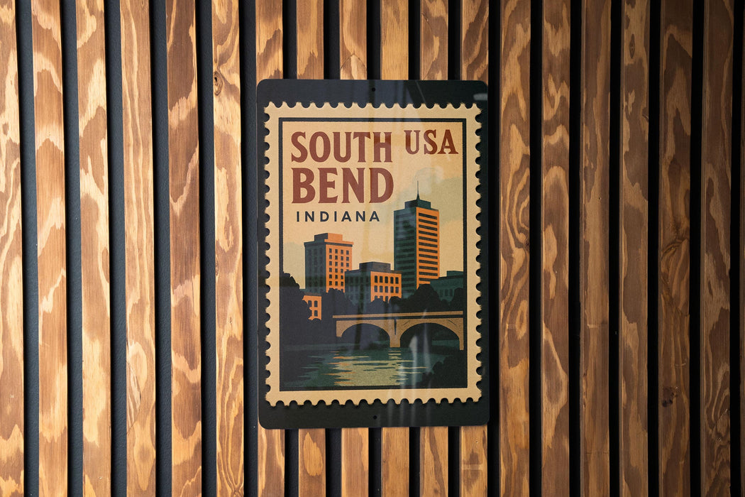 A vintage-style poster of South Bend, Indiana, featuring a cityscape and a bridge, is displayed on a wooden wall.