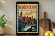 A vintage-style stamp depicting the city of Manchester, New Hampshire, with a clock tower and buildings in the background.