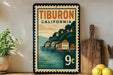 A vintage postage stamp from Tiburon, California, featuring a scenic illustration of a coastal town with houses and a pier.
