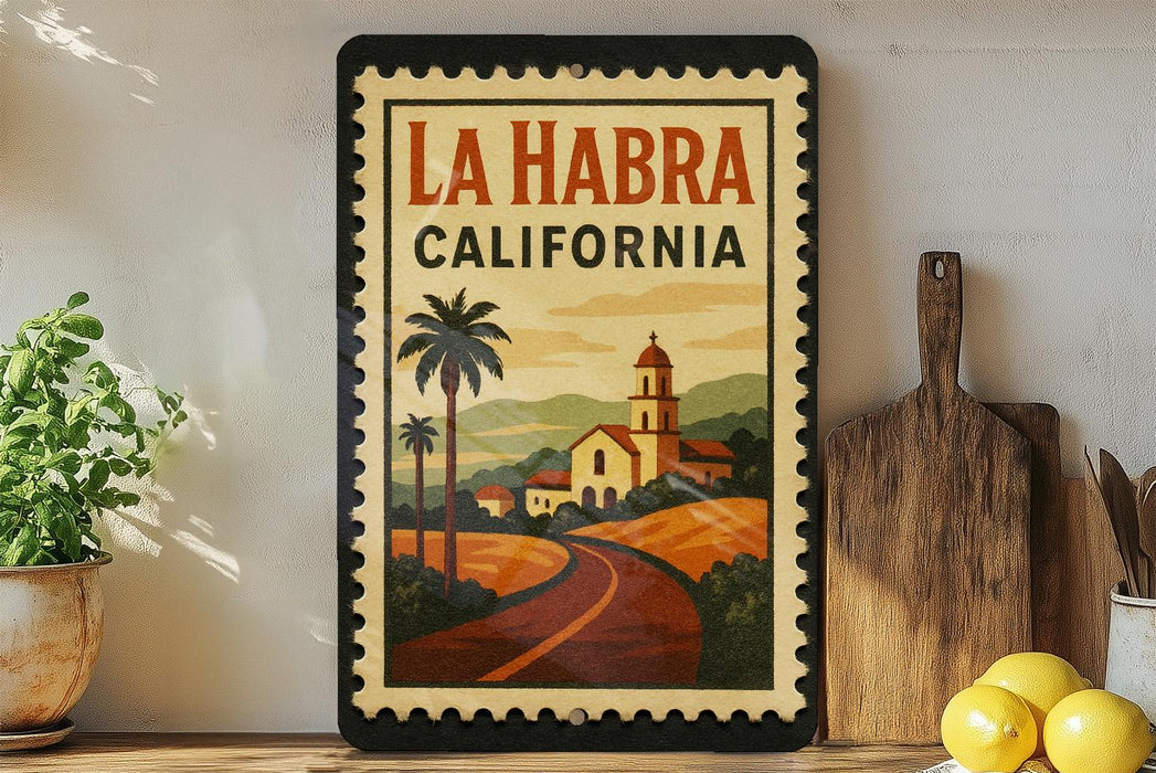 A framed poster of La Habra, California, featuring a scenic illustration of a road leading to a church, surrounded by palm trees and hills.
